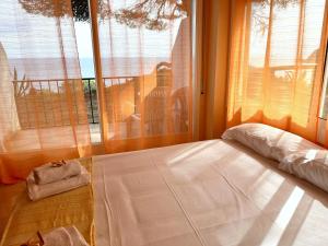 ein Schlafzimmer mit einem Bett und einem großen Fenster in der Unterkunft APPARTEMENTS SOL y MAR - Cala Llevado 2 in Tossa de Mar