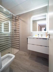 a bathroom with a sink and a toilet and a mirror at Sunflowers in Sanlúcar de Barrameda