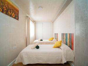 een slaapkamer met 2 bedden en gele kussens bij Sunflowers in Sanlúcar de Barrameda