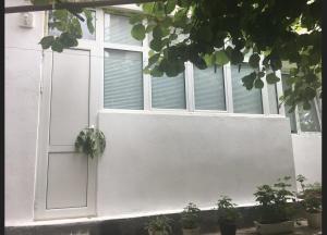 una finestra bianca con piante in vaso davanti di Private Room with lovely yard a Sandanski