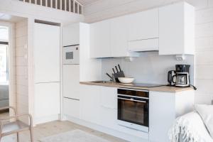 a kitchen with white cabinets and a counter top at Villa Bruno in Syöte