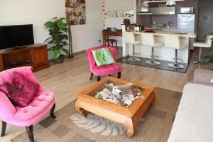 salon z 2 krzesłami i stolikiem kawowym w obiekcie Punauia Quiet apartment with sea view w mieście Punaauia