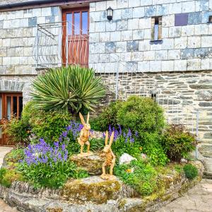 two rabbits in a garden in front of a building at Ta Mill Cottages & Lodges - Hayloft Cottage in Launceston