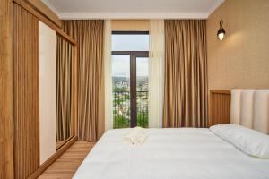 sypialnia z łóżkiem i dużym oknem w obiekcie Apartment by the river w mieście Tbilisi City