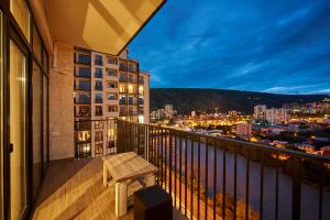 un balcón con un banco en la parte superior de un edificio en Apartment by the river, en Tiflis