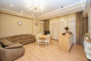 Apartment by the river في تبليسي: غرفة معيشة مع أريكة وطاولة