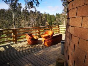 two chairs and a table on a wooden deck at Domos y Cabañas Algarrobo in Algarrobo