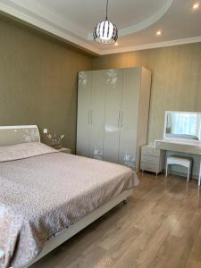 a bedroom with a bed and a dresser and a desk at APARTMENT IN THE NEW CITY in Tbilisi City