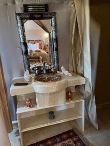 a bathroom with a sink and a mirror at Amskou Camp in Merzouga