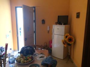 a kitchen with a table and a white refrigerator at Apartment A&M in Marsala