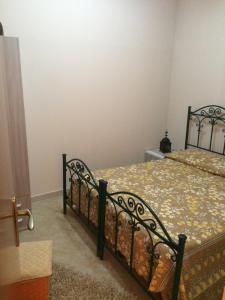 a bedroom with a black bed with a floral bedspread at Apartment A&M in Marsala