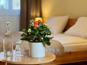 a vase with flowers on a table with a bed at Hotel Marislav in Češnovice