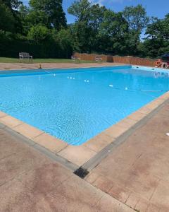 a large blue swimming pool in a yard at Moonlight Lodge in Caeathro