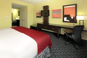 Pokój hotelowy z sypialnią z łóżkiem i biurkiem w obiekcie Holiday Inn Garland, an IHG Hotel w mieście Garland
