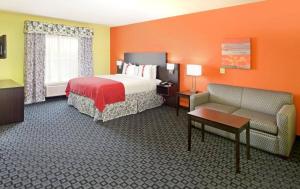 pokój hotelowy z łóżkiem i kanapą w obiekcie Holiday Inn Garland, an IHG Hotel w mieście Garland