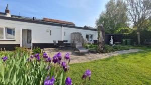 a yard with purple flowers and a house at Roos Guesthouse Holiday Appartements in Schin op Geul