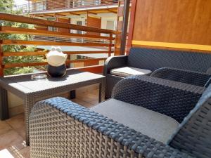 a patio with two chairs and a table with a vase on it at Honey Apartment in Moravske-Toplice