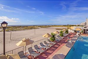 a row of chairs and umbrellas next to the beach at Reges Oceanfront Resort in Wildwood Crest