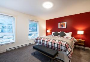 a bedroom with a bed with a red wall at Alpine Escape by Revelstoke Vacations in Revelstoke