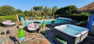 una piscina con jacuzzi en un patio en Hostellerie Saint-Jacques en Saint-Saud-Lacoussière