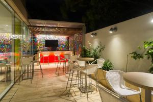 a room with a bar with chairs and a tv at bh Barranquilla in Barranquilla