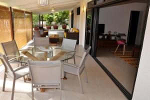 プナアウィアにあるAppartement Villa Taina piscineのダイニングルーム(ガラスのテーブル、椅子付)