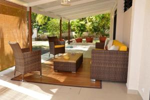 プナアウィアにあるAppartement Villa Taina piscineのパティオ(籐の椅子、テーブル付)