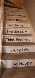 a stairwell with a sign on it that says work hard eat healthy exercise daily at Kind -& diervriendelijk huisje in De Panne