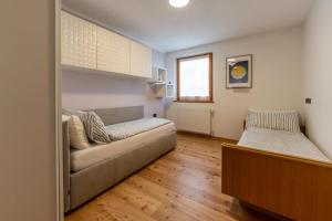 un salon avec un canapé et un lit dans l'établissement CASA BEBA - trilocale accogliente, Dolomiti Affitti, à Cavalese