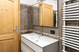 un bagno con un lavandino bianco e uno specchio di CASA BEBA - Cavalese Olimpiadi 2026 Dolomiti Affitti a Cavalese Altre 37 foto