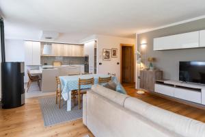 un salon et une cuisine avec un canapé et une table dans l'établissement CASA BEBA - trilocale accogliente, Dolomiti Affitti, à Cavalese