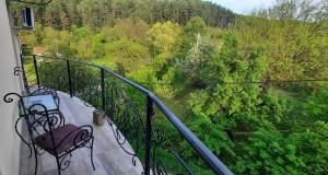 a balcony with a bench and a view of a forest at Apartman ALEX LUX in Vrnjačka Banja