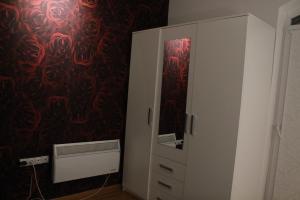 Vrnjačka BanjaにあるApartman ALEX LUXの白いキャビネット(鏡付) +5枚の写真