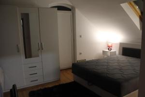 een slaapkamer met een bed en een dressoir met een spiegel bij Apartman ALEX LUX in Vrnjačka Banja