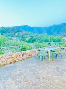 einen Tisch und Stühle auf einer Steinmauer in der Unterkunft Villa Arancia Quiet, Central, Parking and Air Conditioning in Levanto