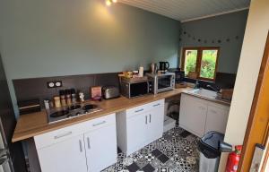 cocina con armarios blancos y encimera en Les chambres du Bonheur en Fontaine-sous-Jouy
