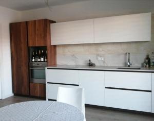 een witte keuken met witte kasten en een spoelbak bij Apartment Lake Garda in Garda