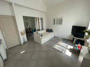 a living room with a couch and a tv at Le Pavillon de la mare in Avrainville