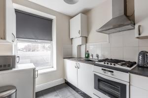 een keuken met witte apparatuur en een raam bij RST Stanley Park in Liverpool