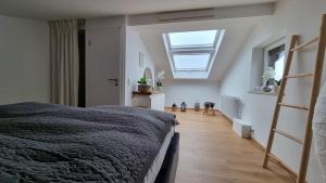 a bedroom with a large bed and a skylight at FeWo AllgäuPhorie, Oberreute in Oberreute