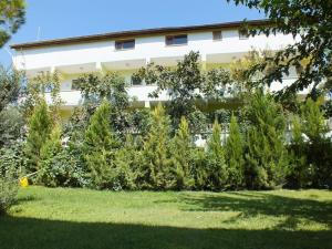 un bâtiment avec des arbres et des buissons devant lui dans l'établissement GÜNEŞ APART OTEL, à Pamukkale