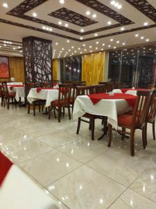 una sala da pranzo con tavoli e sedie in un ristorante di Rendezvous hotel petra a Wadi Musa