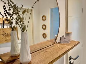 a bathroom with two white vases and a mirror at City-Apartment⎪Domblick⎪Marktplatz in Bremen