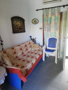 a bedroom with a bed and a blue chair at private house next to the sea in Pefkochori