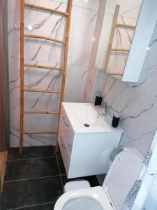 een badkamer met een witte wastafel en een toilet bij Tiny house by the sea in Nea Skioni