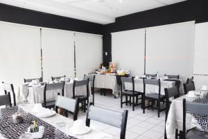 a dining room with tables and chairs and windows at Hotel Concorde in Arica
