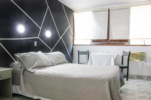 1 dormitorio con 1 cama y pared en blanco y negro en Hotel Concorde, en Arica