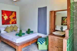 1 dormitorio con cama y espejo en Magnifique Villa Vue Mer exceptionnelle - Ireina en Punaauia