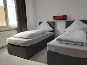 two beds with white pillows in a room at Nordunterkunft in Neumünster