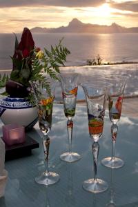 un grupo de copas de vino sentado sobre una mesa en Magnifique Villa Vue Mer exceptionnelle - Ireina en Punaauia